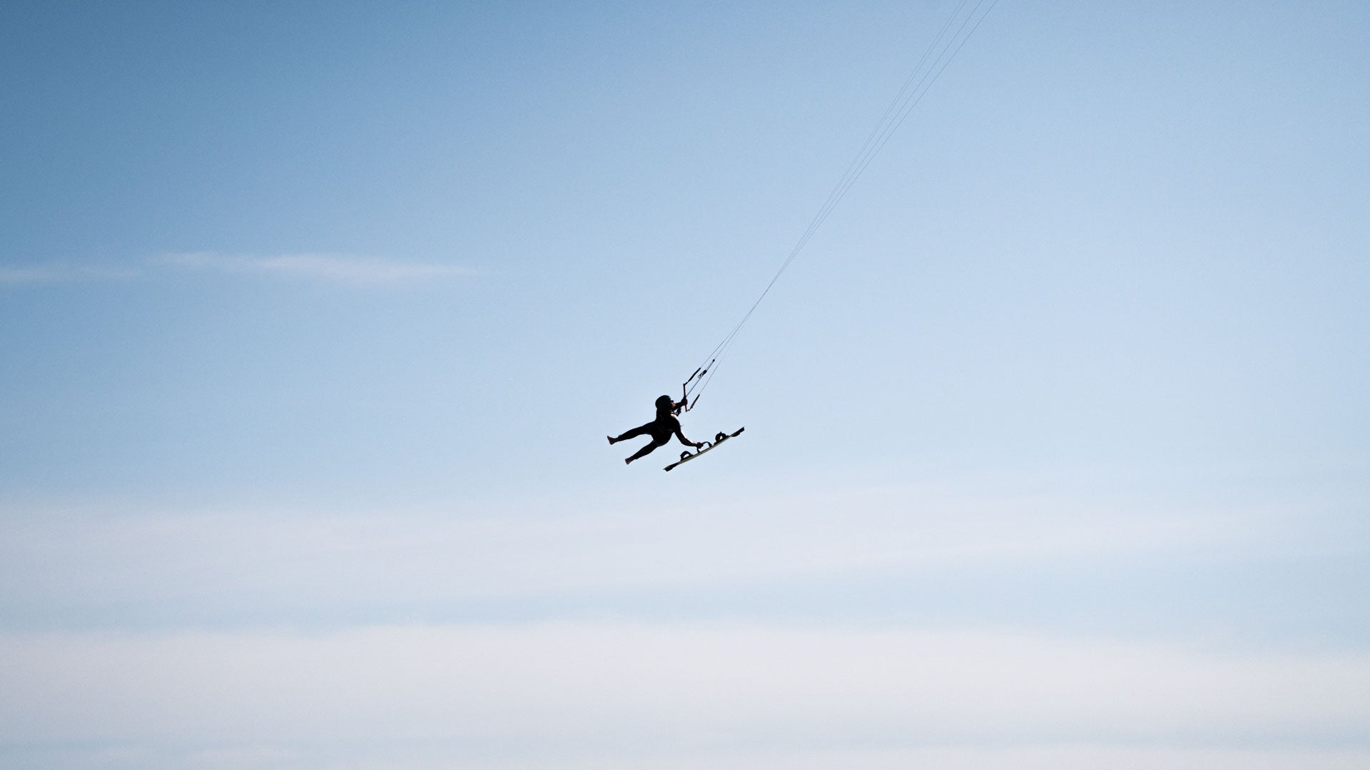 Panoramski pogled na kajtarja z Flysurfer opremo na mirni morski gladini – idealna scena za avanturiste in ljubitelje potovanj.